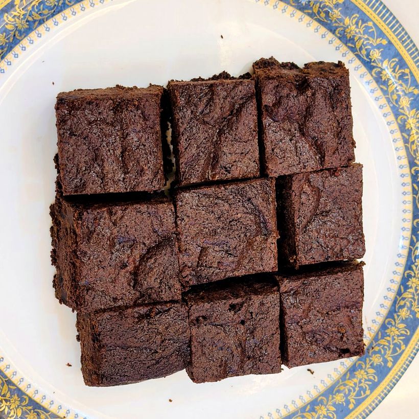 A plate of nine fudgy chocolate brownies with a crackly top